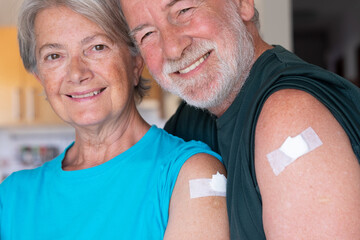 Beautiful senior couple 70 years old smiling after receiving the booster of the coronavirus covid-19 vaccine. Concept of prevention and immunization - obrazy, fototapety, plakaty