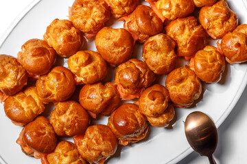 Profiteroles stuffed with fish, decorated with tomatoes. Flat layout.