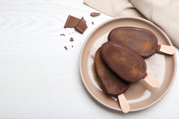 Delicious glazed ice cream bars and chocolate on white wooden table, flat lay. Space for text