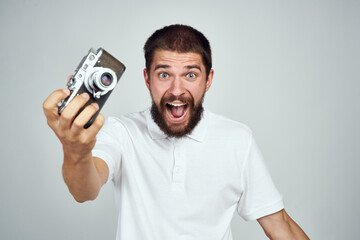Cheerful man with a camera in his hands. Professional fashion lifestyle.