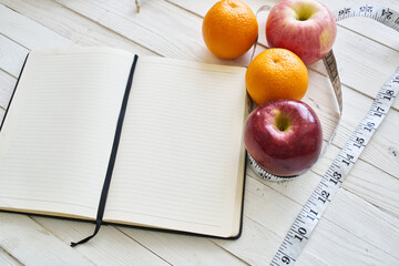 notepad on table measuring tape fruit breakfast nutritional fitness