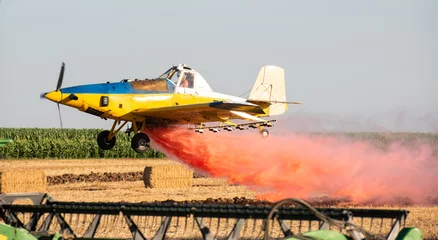 Cercles muraux Ancien avion low flight of agricultural propeller plane is spraying  crop protection products.