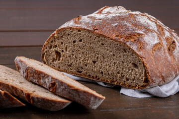 Freshly baked rye bread sliced in the traditional way. Single object on a wooden background. Top view, copy space