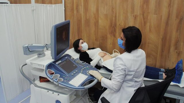 Echoscopy room. Doctor echoscopist observes a pregnant woman. 