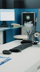 Nobody in cabinet with medical equipment for checkup visit and examination. Close up of desk with computer, documents and tools for consultation in empty doctors office at facility.