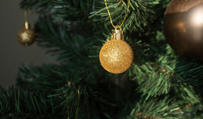 Obraz na płótnie Canvas round golden toy on the Christmas tree weighs