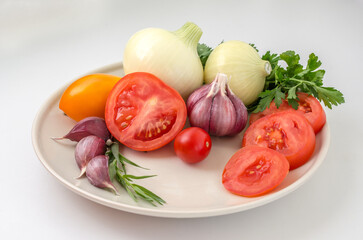 Tomatoes, garlic, onions and greens on a plate
