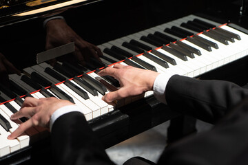 Photo of a professional pianist performing on a grand piano.