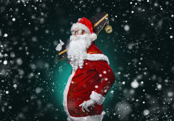 Waist up portrait of cool rock Santa with skateboard over dark background with snow falling, copy space