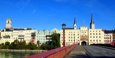 rote Inn-Brücke zum Brucktor von Wasserburg am Inn mit mittelalterlicher Stadtfassade und 3 Kirchtürmen