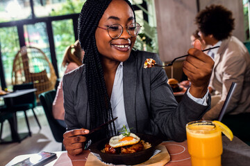 African American businesswoman having lunch in restaurant.