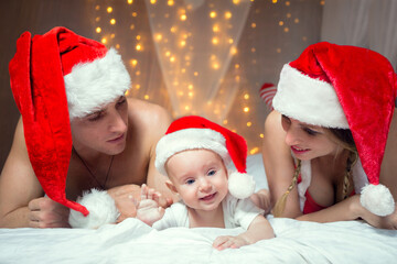 Family in Christmas Hat, Baby, Mother and Father on White bed