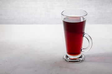 Glass cup with drink on gray concrete background, minimalism, copy space