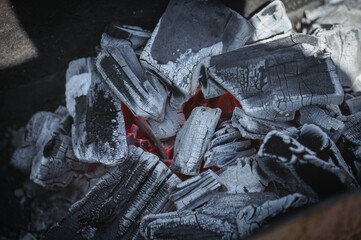 Smoldering coals in the grill. Preparation for frying meat on coals. Close-up, selective focus