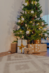 Christmas gifts wrapped in kraft paper under christmas tree.