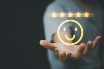 Businessman holding and select smiley face icon for customer feedback rating and evaluation concept.