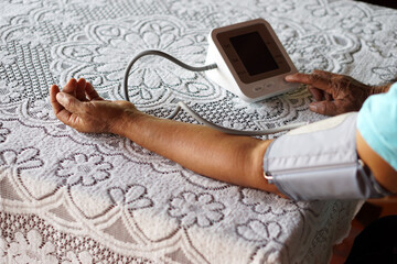 Senior woman uses blood pressure machine. Concept : Health checking at home. Healthcare. Medical...