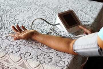 Senior woman's arm uses blood pressure machine. Concept : Health checking at home. Healthcare....