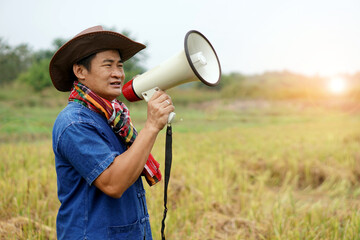 Asian man wears hat, plaid shirt, hold megaphone. Concept : communication , announcement. Protest. Protester. Announce something to the world. Bullhorn public address megaphone.