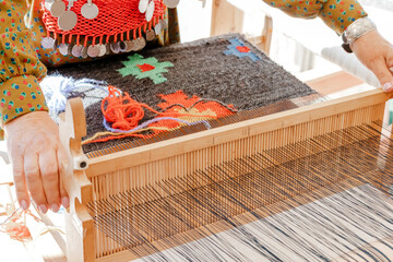 spinning cotton thread with a wooden retro craftsman spinner machine. Culture and tradition concept