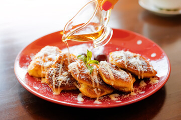 maple syrup is poured on sweet pancakes. Delicious dessert with an overabundance of fast...