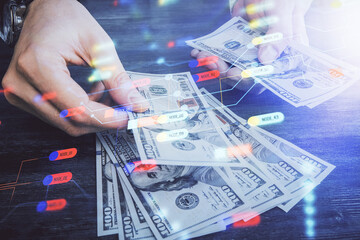 Multi exposure of technology drawing hologram and us dollars bills and man hands. Data concept