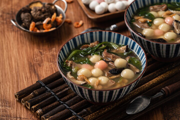 Red and white tangyuan with savory soup.