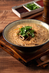 Delicious intestine vermicelli in a bowl on dark wooden table background.