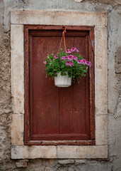 Fototapeta na wymiar The ancient window and flowerpot of building in Croatia