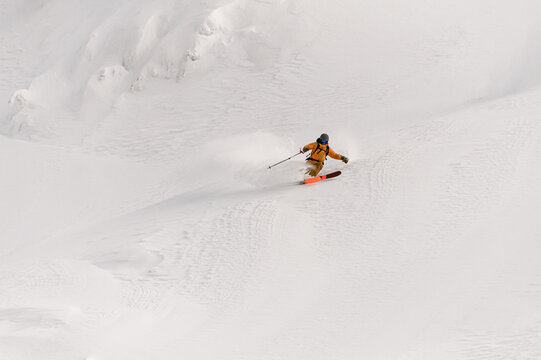 freeride skier rides on powder snow down the slope