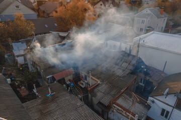 
Severe fire in a private house. the roof is on fire. Thick smoke in the sky. Photo from the drone. Rescuers put out the fire.