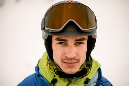 Head shot of handsome man skier wearing ski helmet with goggles