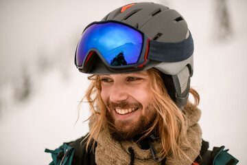Portrait of joyful man skier wearing ski helmet with goggles