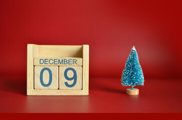 December 9, Calendar design with Christmas tree on red table background.