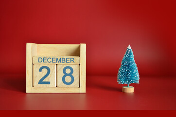 December 28, Calendar design with Christmas tree on red table background.
