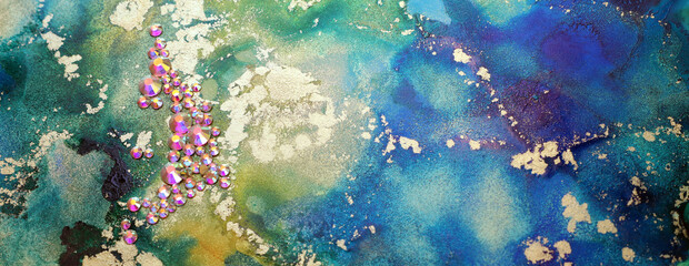 art photography of abstract fluid art painting with alcohol ink blue, green, gold colors and crystal rhinestones