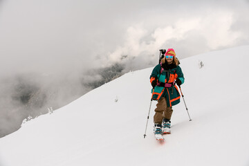 front view of smiling man skier walking along snowy hill trail