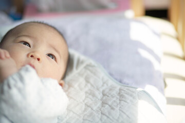 お布団の上でゴロゴロする赤ちゃん