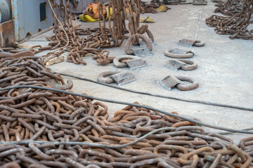 Safe cargo lashing onboard of ship deck with cargo lashing chains and tensioner.