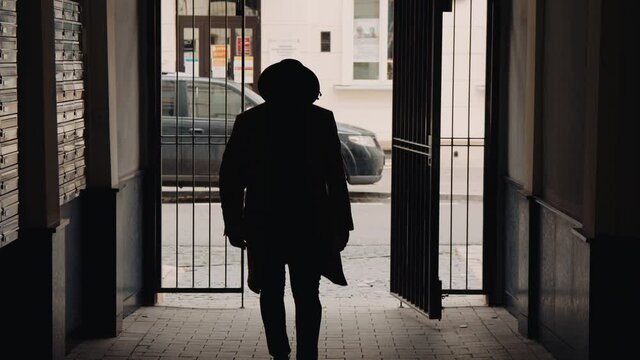 Suspicious type dark character walking towards the camera