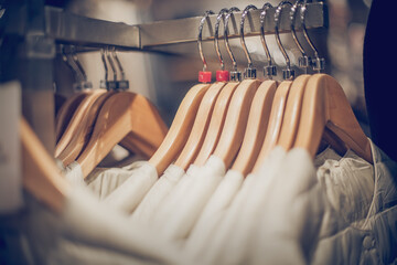 Hangers with clothes on the rail in the store. Shopping in store. Clothes on hangers in shop for sale