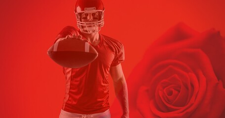 Portrait of confident athlete holding american football's ball over red rose background