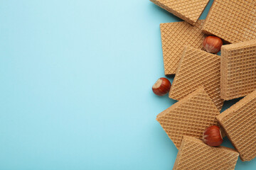 Square chocolate wafer biscuits with hazelnut on blue background.