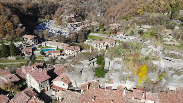 Aerial: flying over a small town in mountainous terrain in the catalan countryside. Cirular shot