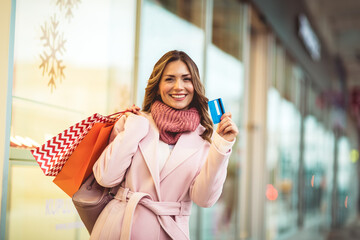 Christmas Shopping. Beautiful happy woman with credit card and shopping bags