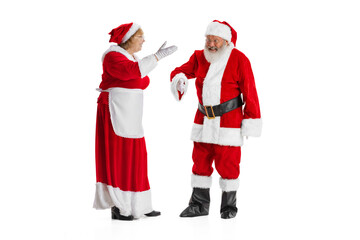 Two people, elder man and woman, Santa Claus and missis Claus in traditional New Year costume talking isolated on white background.