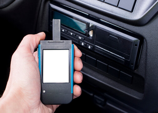 Driver holding a digital tachograph reader with isolated white screen. Tachograph download.