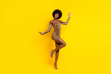 Photo of beautiful adorable dark skin woman dressed leopard outfit dancing smiling isolated yellow...