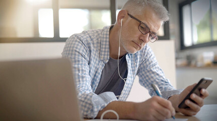 man telecommuting on his laptop at home