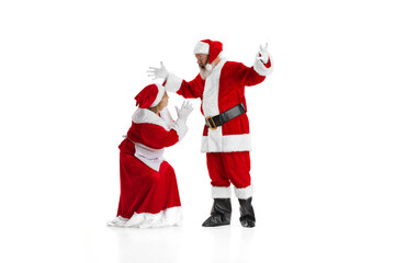 Angry elder man, Santa Claus shouting at woman, missis Claus isolated on white background.